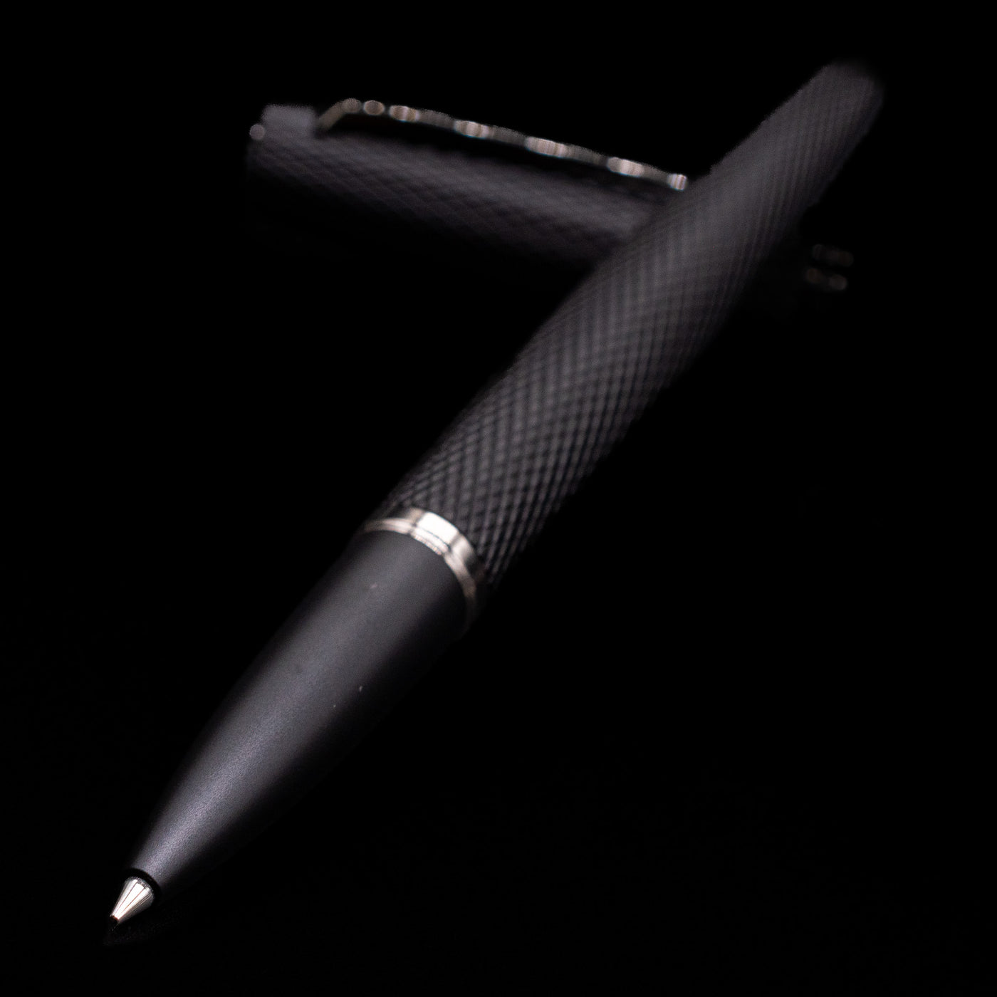 Diplomat Viper Rollerball Pen - Black laying across its own cap, crossed, with a focus on the tip.