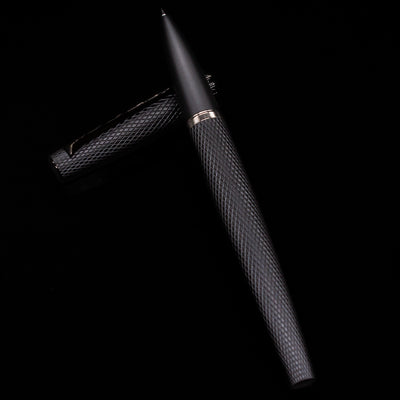 Diplomat Viper Rollerball Pen - Black laying on top of its cap in a crossed position showing full view of the entire uncapped pen.