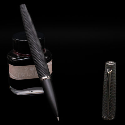 Diplomat Viper Rollerball Pen - Black leaning on an ink bottle uncapped.