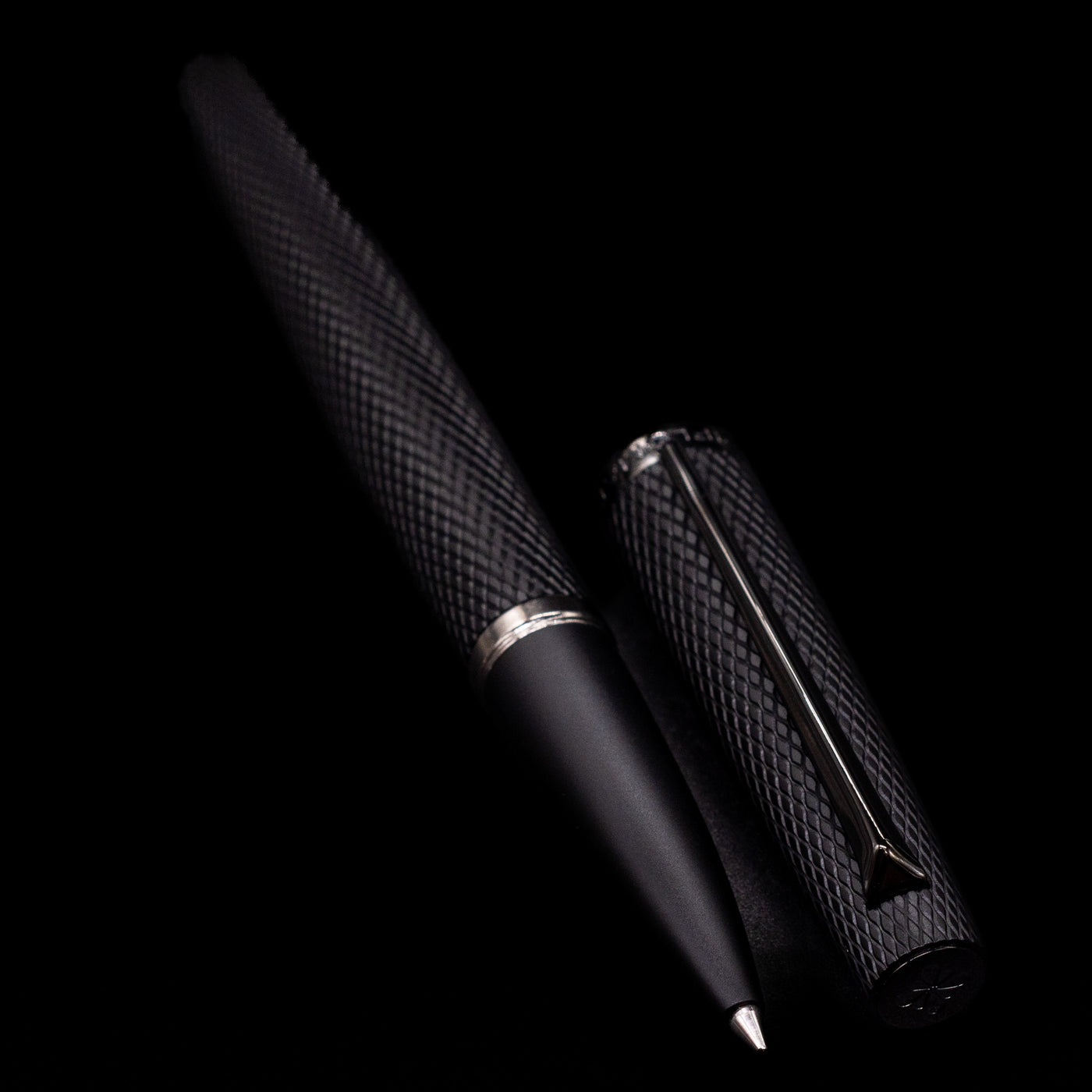 A full view of the Diplomat Viper Rollerball Pen - Black uncapped, with its cap laying next to the pen. 