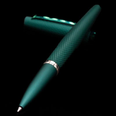 Diplomat Viper Rollerball Pen - Green laying across its own cap, crossed, with a focus on the tip.