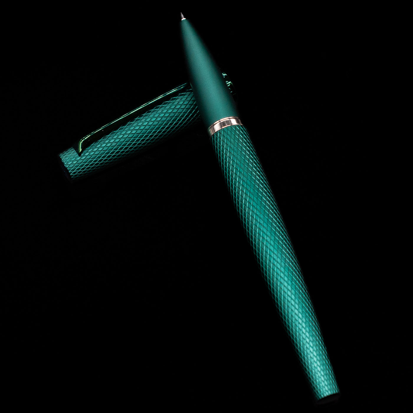 Diplomat Viper Rollerball Pen - Green laying on top of its cap in a crossed position showing full view of the entire uncapped pen.