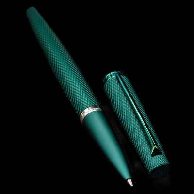 A full view of the Diplomat Viper Rollerball Pen - Green uncapped, with its cap laying next to the pen. 