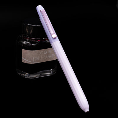 Faber-Castell Avori Ballpoint Pen - Dream Weaver leaning against an ink bottle.