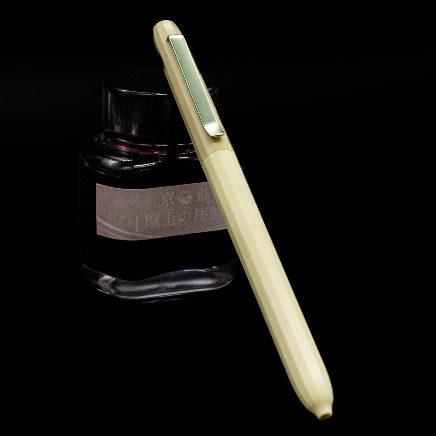 Faber-Castell Avori Ballpoint Pen - Fresh Breeze leaning against an ink bottle. 