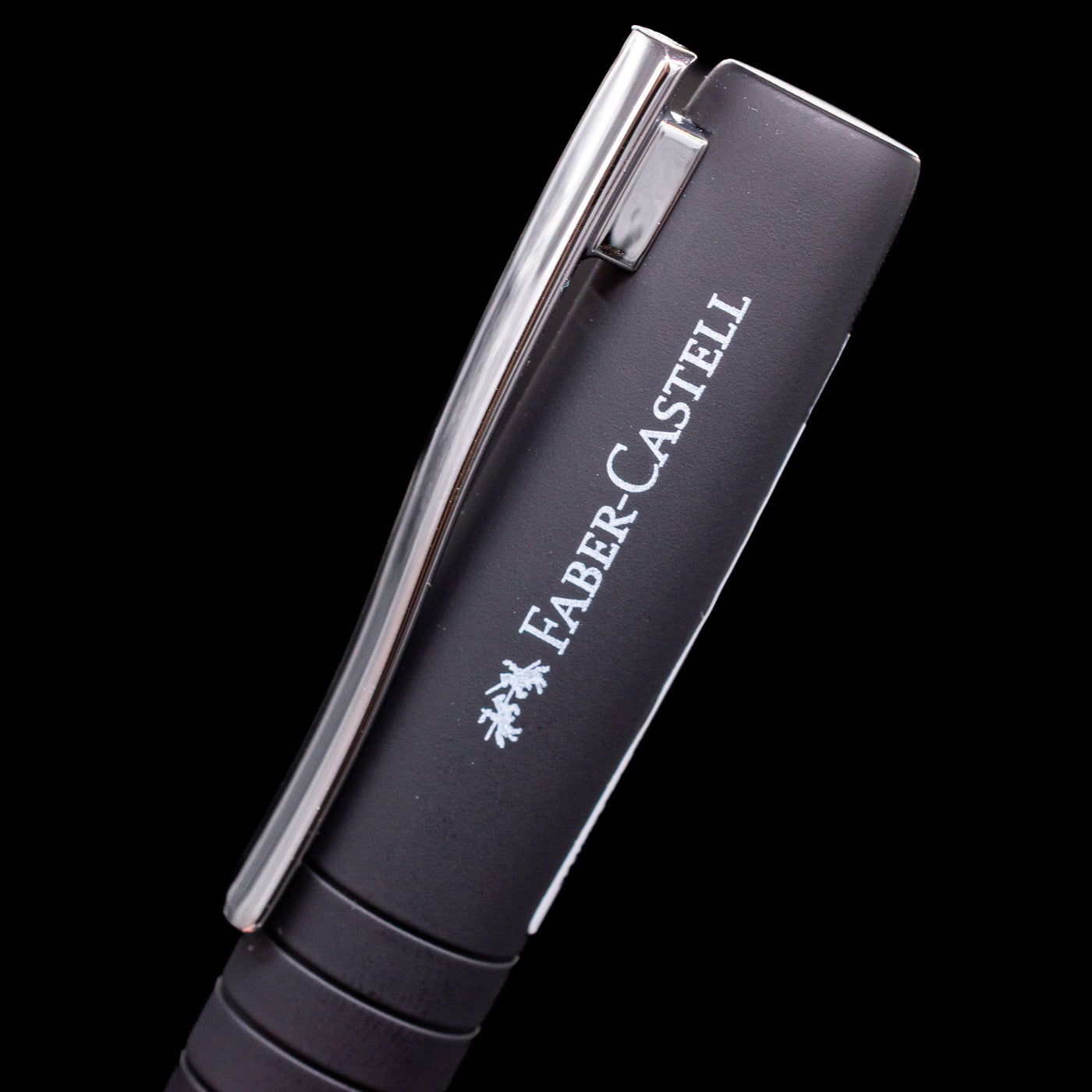 A close-up view of the logo and name of the brand on the side of the cap on the Faber-Castell Poly Fountain Pen - Black.