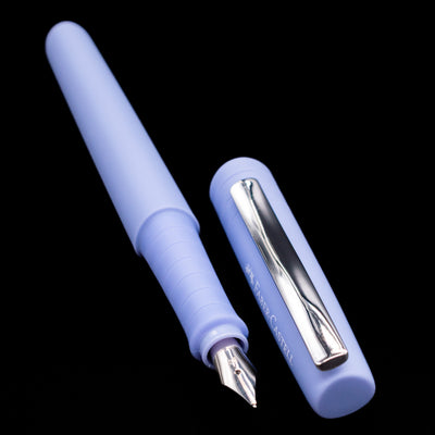  A full view of the Faber-Castell Poly Fountain Pen - Caribic Blue uncapped, with its cap laying next to the pen. 