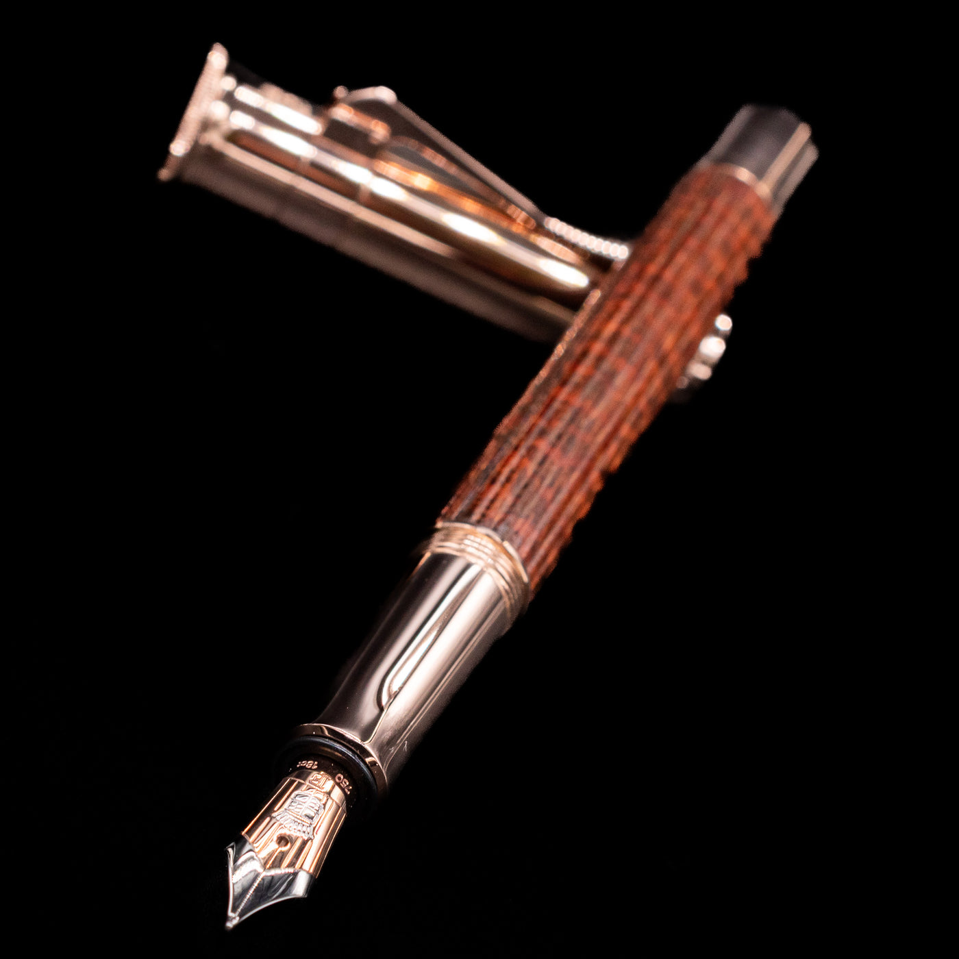 Graf von Faber-Castell Classic Limited Edition fountain pen and cap crossed with the nib in sharp focus, showing fine detailing.
