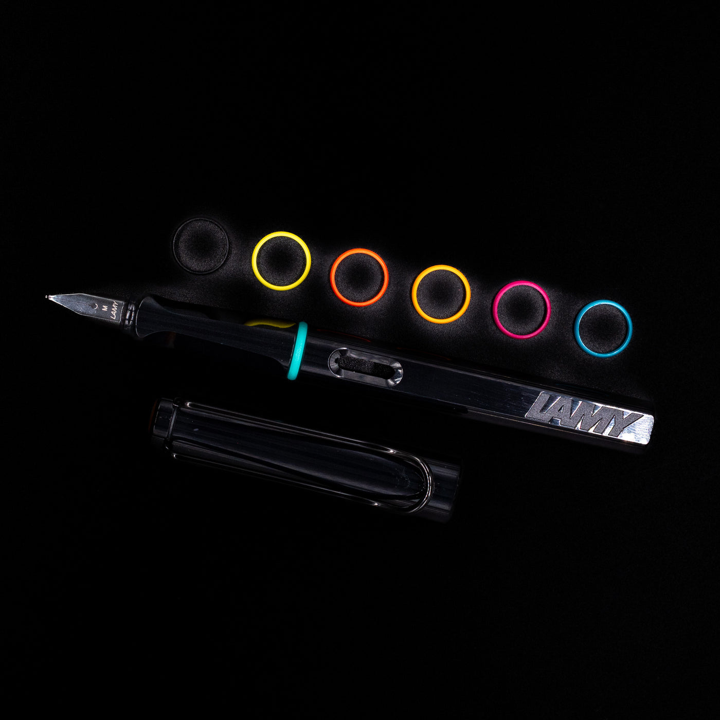 Overhead shot of the capped LAMY Safari Multi Fountain Pen in glossy black, showing clip shape and cap design with the six colorful rings available.