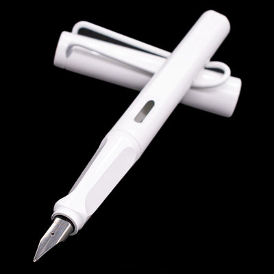 Pen and cap crossed with the nib in sharp focus, highlighting the clean white body and metal nib of the LAMY Safari Multi Fountain Pen.