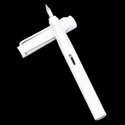 Uncapped white Safari Multi laid across its cap, showcasing the ergonomic grip section and minimalist design.