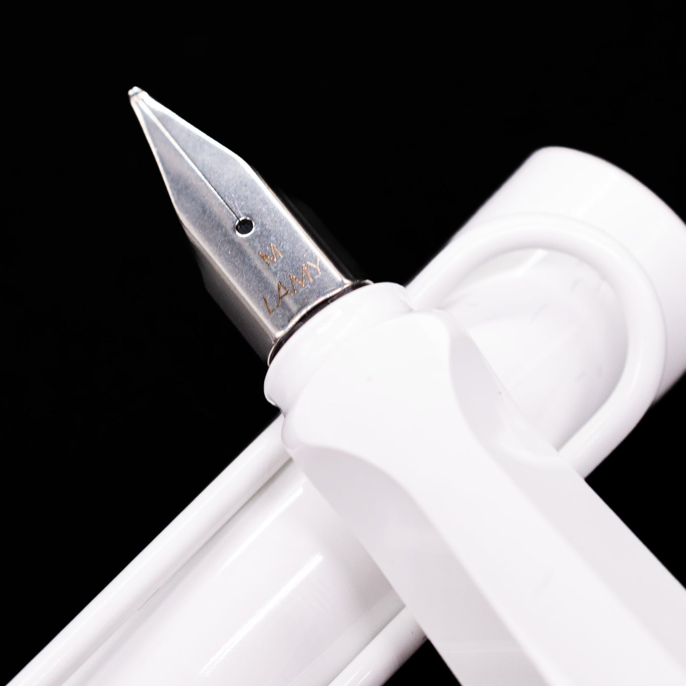 Detailed macro shot of the polished nib, showing engraved LAMY branding on the LAMY Safari Multi Fountain Pen in glossy white.