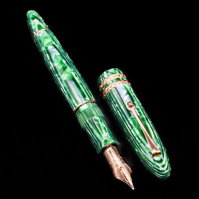 A full view of the Leonardo Cigar Leonardo Verde Celluloid Fountain Pen uncapped, with its cap laying next to the pen. 