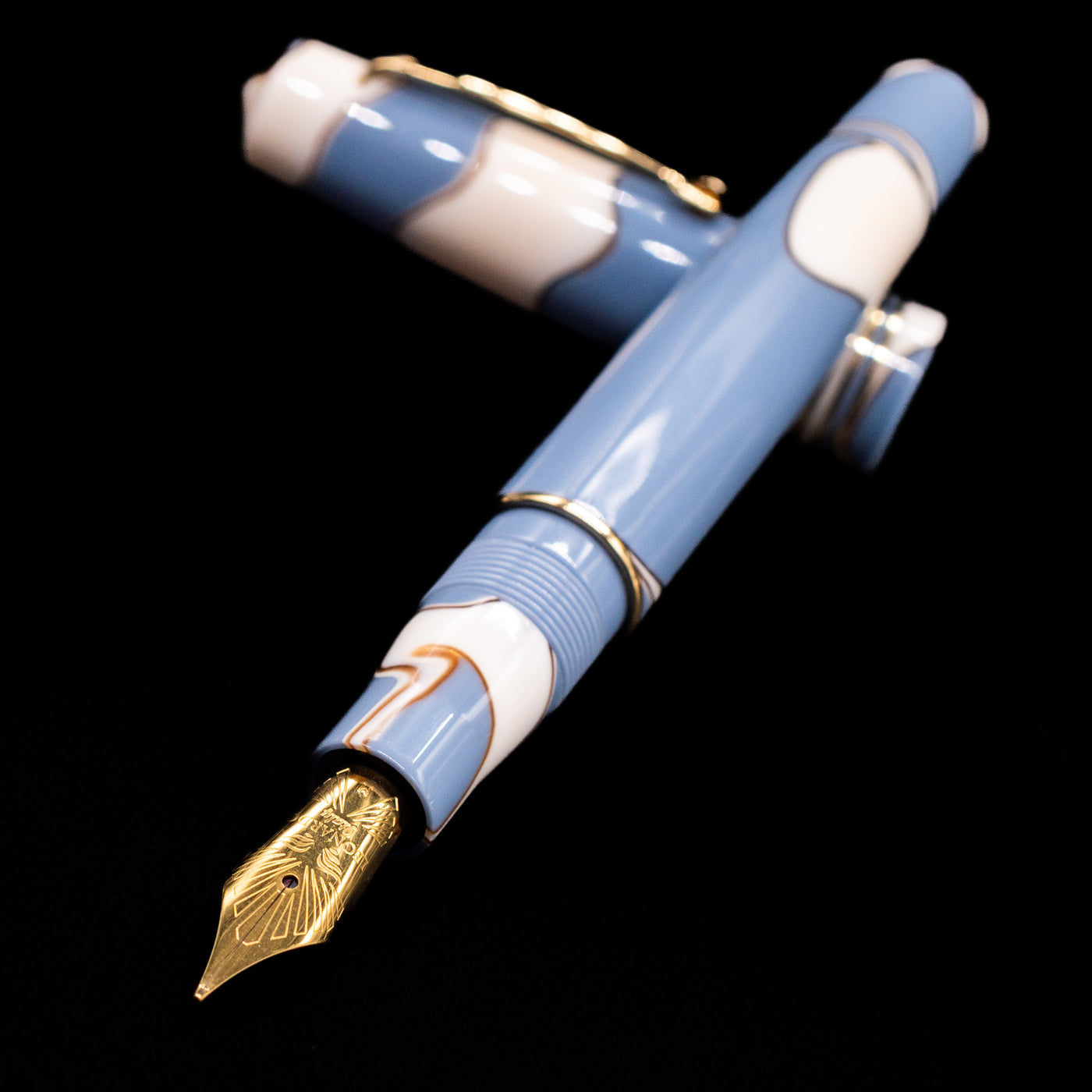 Leonardo Momento Zero Lavanda Gold Trim Fountain Pen - Preowned laying across its own cap, crossed, with a focus on the nib.