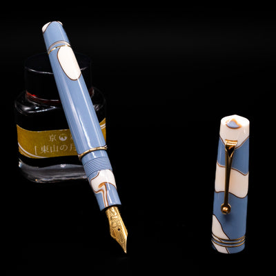 Leonardo Momento Zero Lavanda Gold Trim Fountain Pen - Preowned leaning on an ink bottle uncapped showcasing the detailing on the nib.
