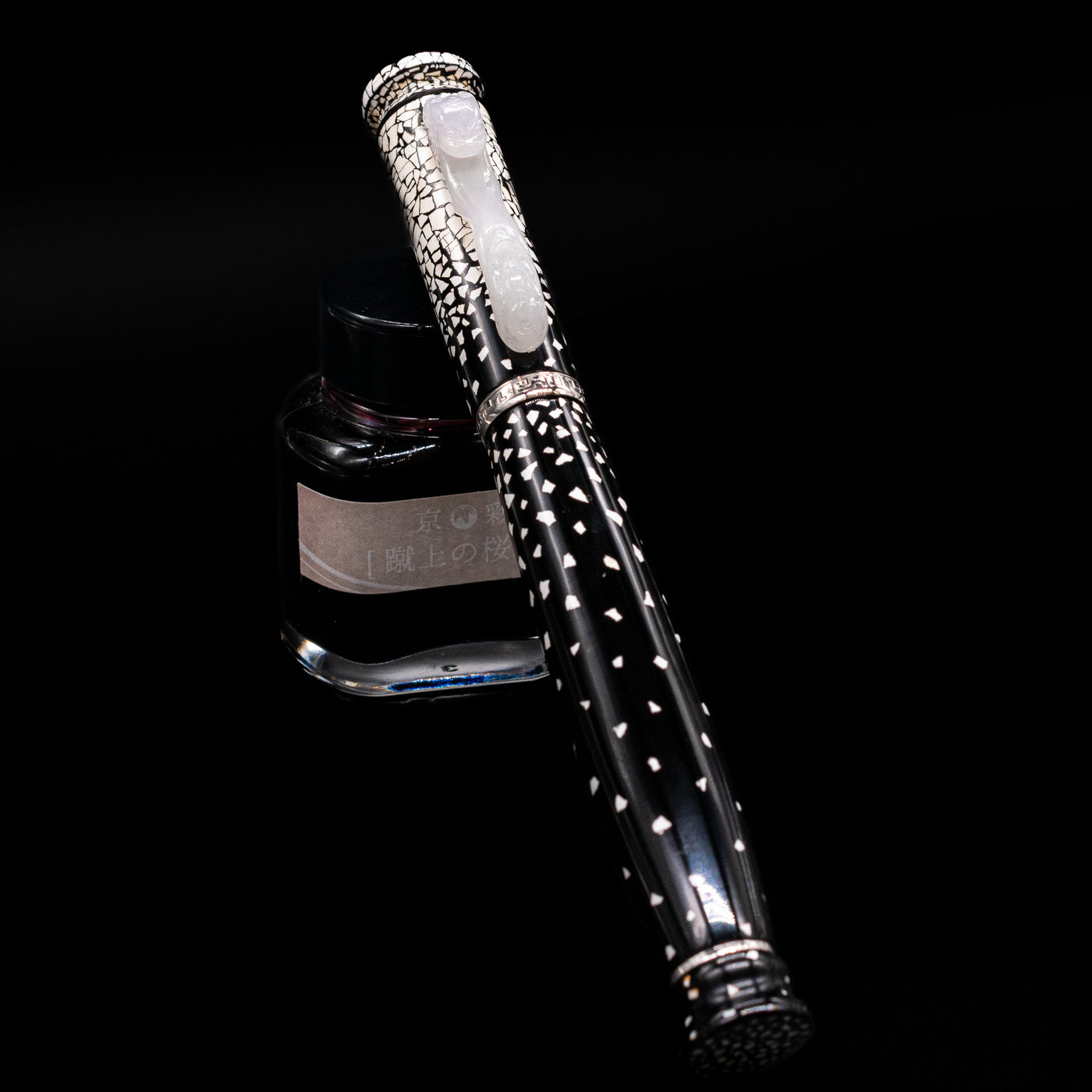 Loiminchay Snow with Jade Clip Fountain Pen capped, leaning against an ink bottle. 