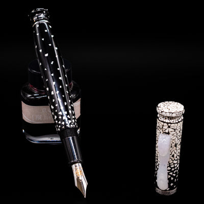 Loiminchay Snow with Jade Clip Fountain Pen leaning on an ink bottle uncapped showcasing the detailing on the nib.