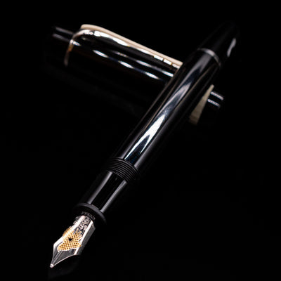 Montblanc Donation Herbert von Karajan Fountain Pen - Preowned laying across its own cap, crossed, with a focus on the nib.
