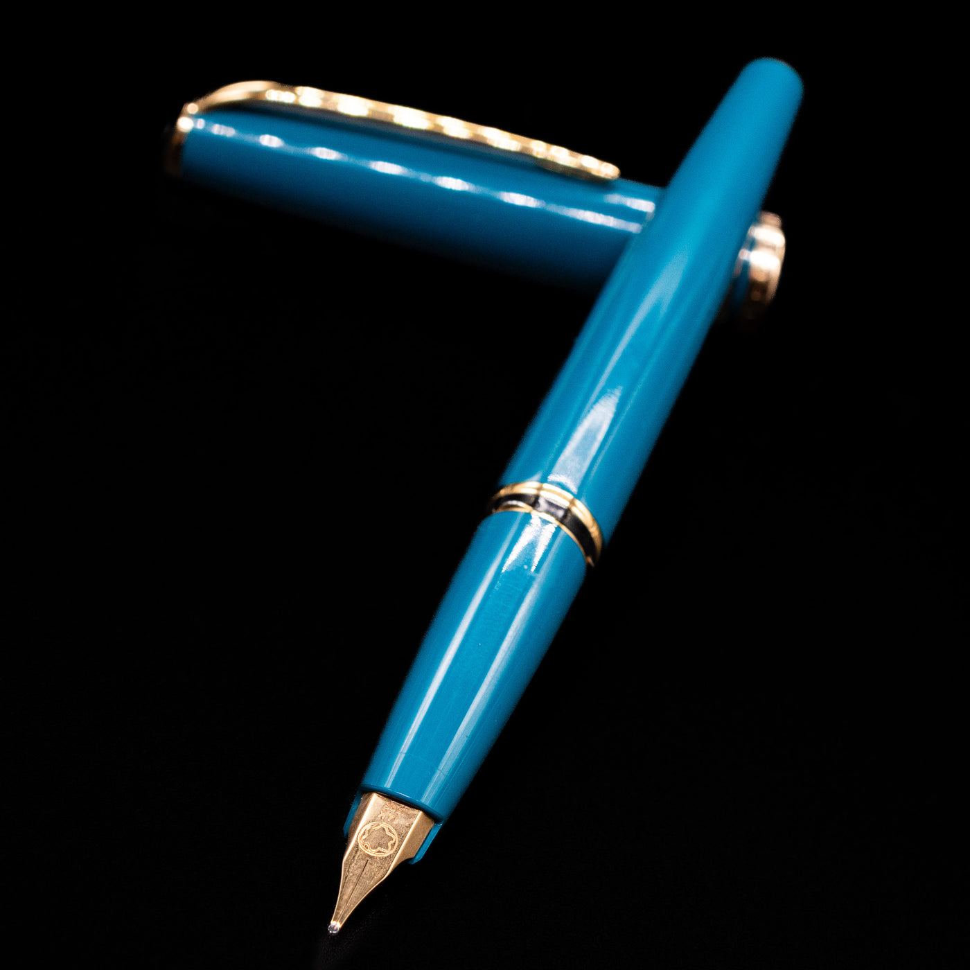 Montblanc Generation Turquoise Fountain Pen - Preowned laying across its own cap, crossed, with a focus on the nib.