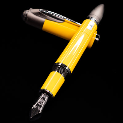 Montblanc Great Characters Enzo Ferrari Fountain Pen - Giallo Modena laying across its own cap, crossed, with a focus on the nib.