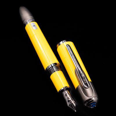 A full view of the Montblanc Great Characters Enzo Ferrari Fountain Pen - Giallo Modena uncapped, with its cap laying next to the pen. 