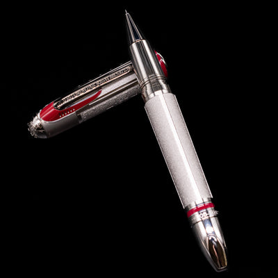 Montblanc Great Characters Enzo Ferrari Limited Edition 1898 Rollerball Pen - Preowned laying on top of its cap in a crossed position showing full view of the entire uncapped pen.