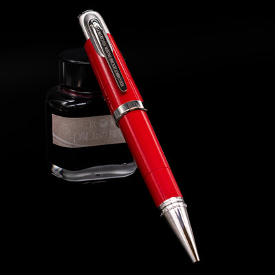 Montblanc Great Characters Enzo Ferrari Special Edition Ballpoint Pen - Preowned leaning against an ink bottle.