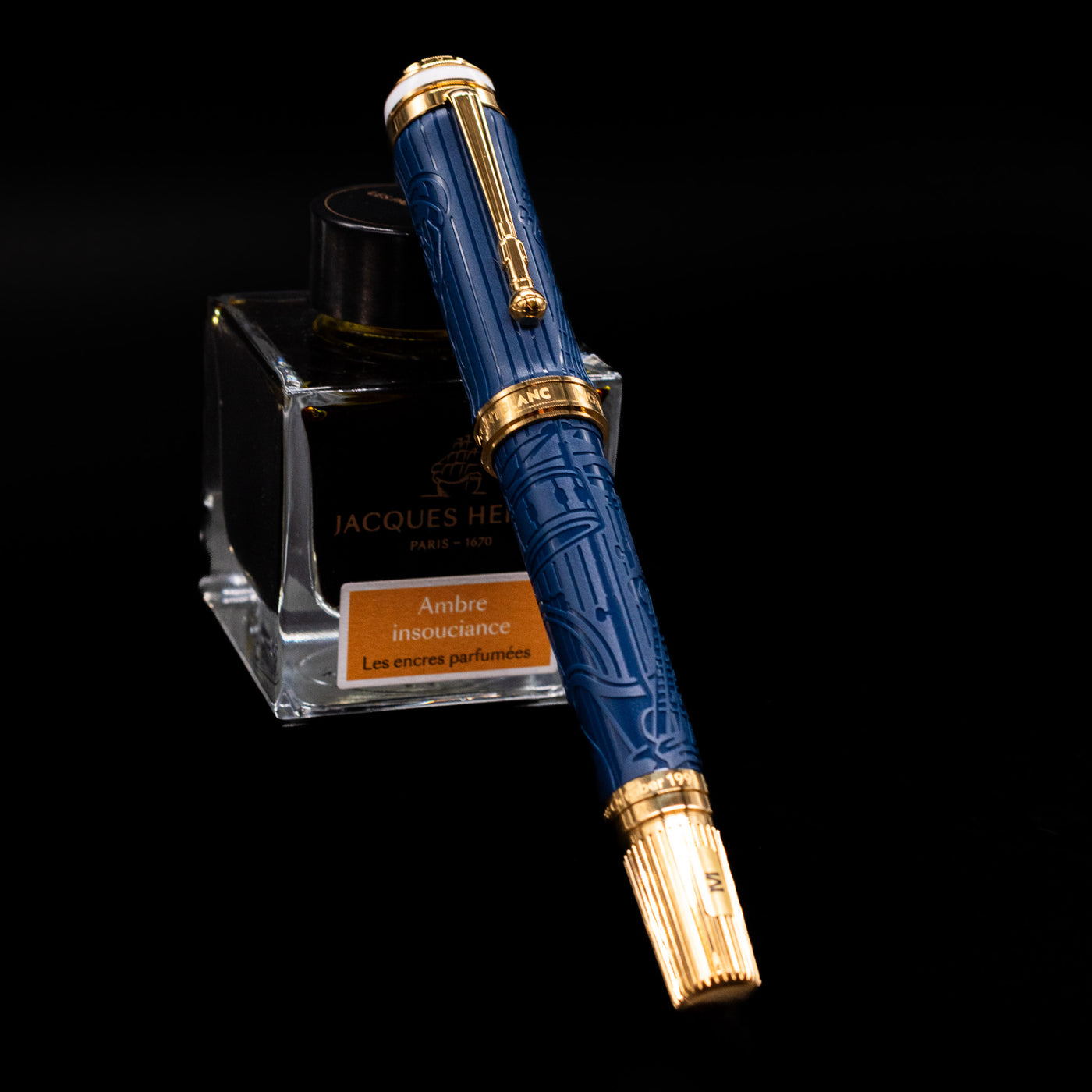 Montblanc Great Characters Homage to Queen Fountain Pen capped, leaning against an ink bottle. 