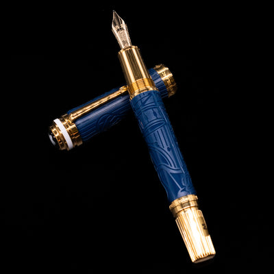 Montblanc Great Characters Homage to Queen Fountain Pen laying on top of its cap in a crossed position showing full view of the entire uncapped pen.