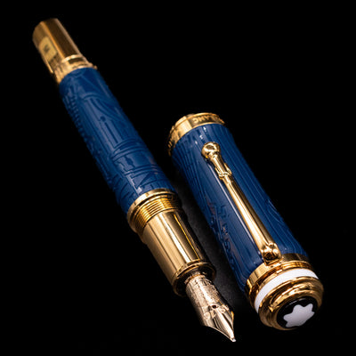 A full view of the Montblanc Great Characters Homage to Queen Fountain Pen uncapped, with its cap laying next to the pen. 