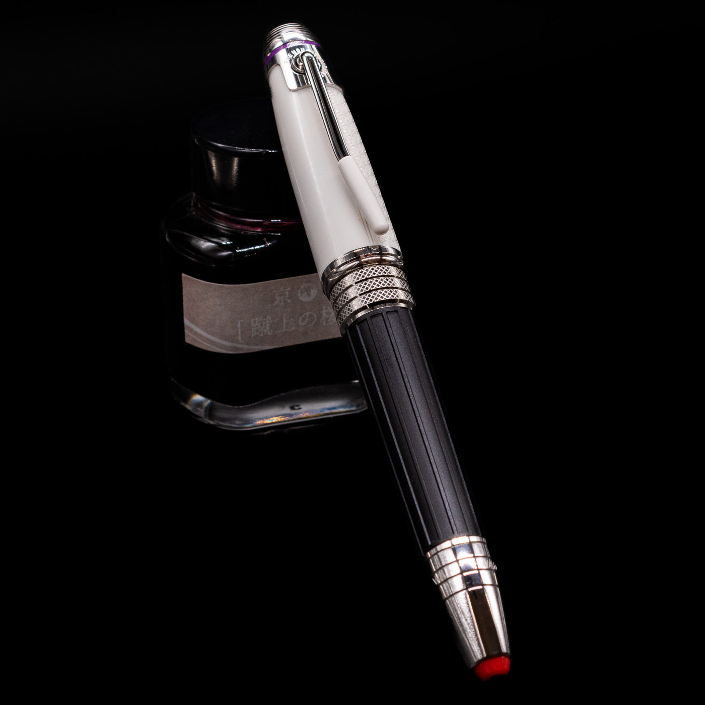 Montblanc Great Characters Jimi Hendrix Fountain Pen capped, leaning against an ink bottle. 