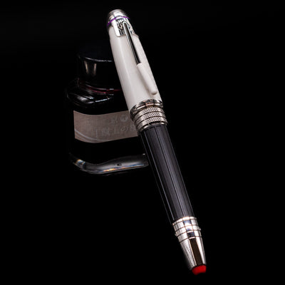 Montblanc Great Characters Jimi Hendrix Fountain Pen capped, leaning against an ink bottle. 