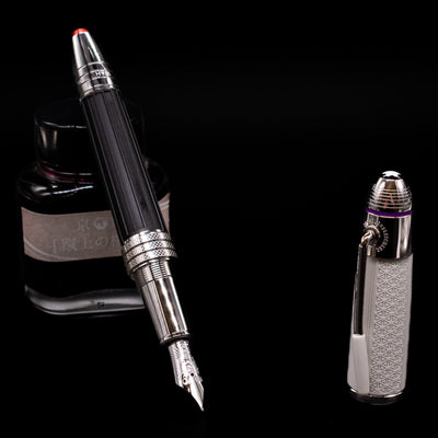 Montblanc Great Characters Jimi Hendrix Fountain Pen leaning on an ink bottle uncapped showcasing the detailing on the nib.