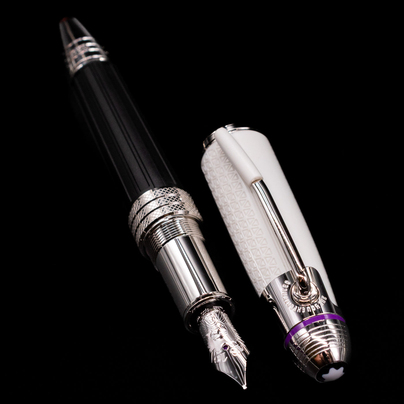  A full view of the Montblanc Great Characters Jimi Hendrix Fountain Pen uncapped, with its cap laying next to the pen. 