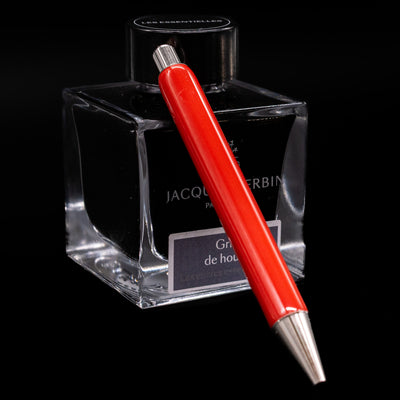 Montblanc Heritage Baby Ballpoint Pen - Coral leaning on an ink bottle.