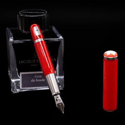 Montblanc Heritage Baby Fountain Pen - Coral leaning on an ink bottle uncapped showcasing the detailing on the nib.
