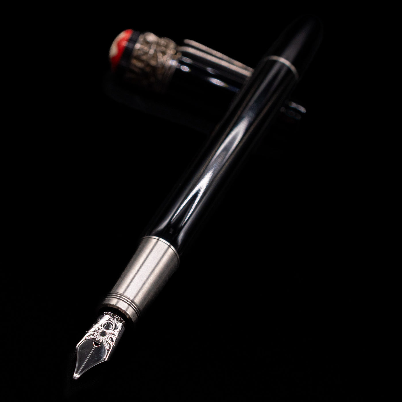 Montblanc Heritage Collection Metamorphosis Fountain Pen - Preowned laying across its own cap, crossed, with a focus on the nib.