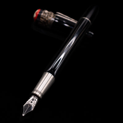 Montblanc Heritage Collection Metamorphosis Fountain Pen - Preowned laying across its own cap, crossed, with a focus on the nib.