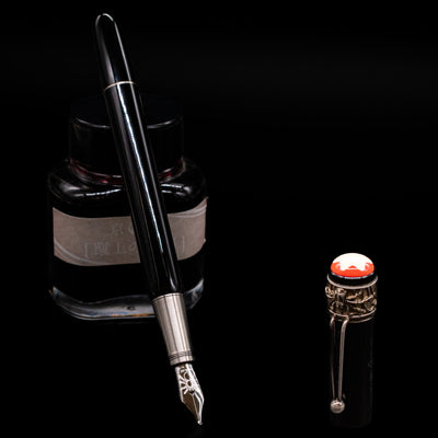 Montblanc Heritage Collection Metamorphosis Fountain Pen - Preowned leaning on an ink bottle uncapped showcasing the detailing on the nib.