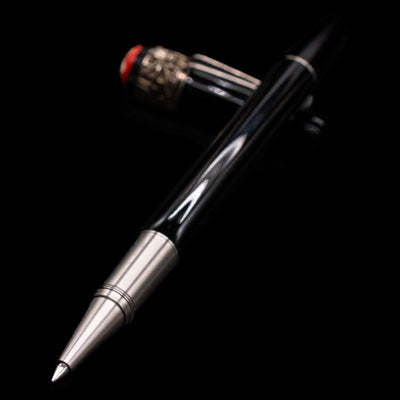 Montblanc Heritage Collection Metamorphosis Rollerball Pen - Preowned laying across its own cap, crossed, with a focus on the tip.