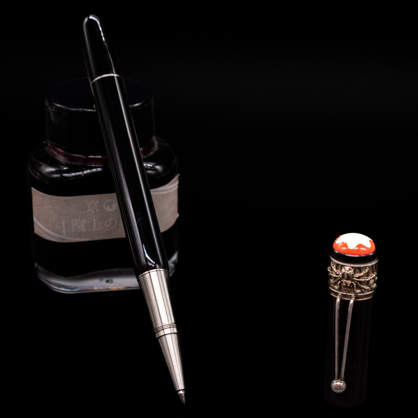 Montblanc Heritage Collection Metamorphosis Rollerball Pen - Preowned leaning on an ink bottle uncapped showcasing the detailing on the tip.