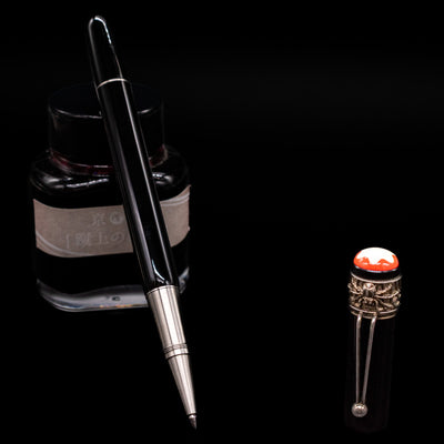 Montblanc Heritage Collection Metamorphosis Rollerball Pen - Preowned leaning on an ink bottle uncapped showcasing the detailing on the tip.