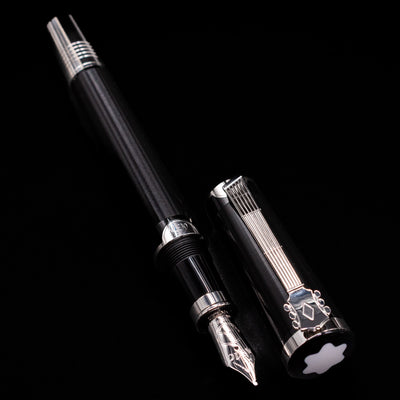 A full view of the Montblanc John Lennon Special Edition Fountain Pen - Preowned uncapped, with its cap laying next to the pen. 