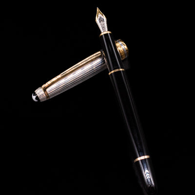 Montblanc Meisterstuck 144DS Solitaire Doue Fountain Pen - Preowned laying on top of its cap in a crossed position showing full view of the entire uncapped pen.