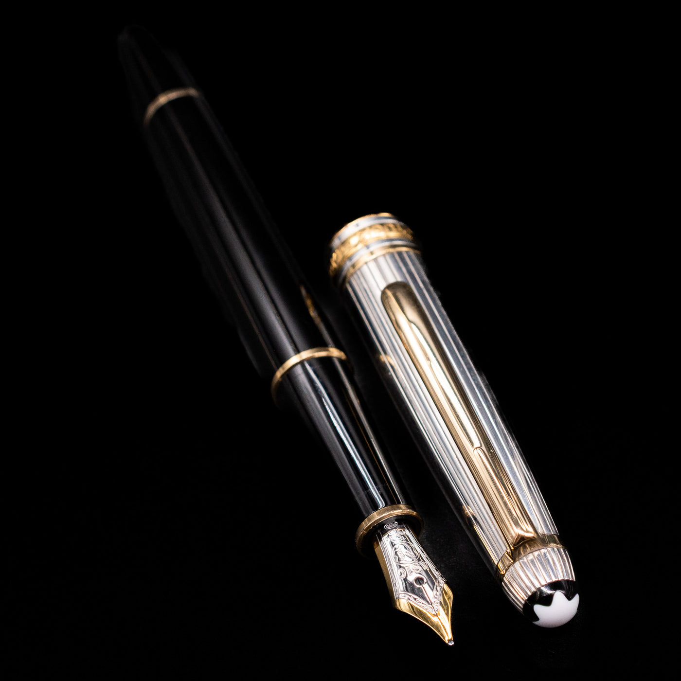 A full view of the Montblanc Meisterstuck 144DS Solitaire Doue Fountain Pen - Preowned uncapped, with its cap laying next to the pen. 