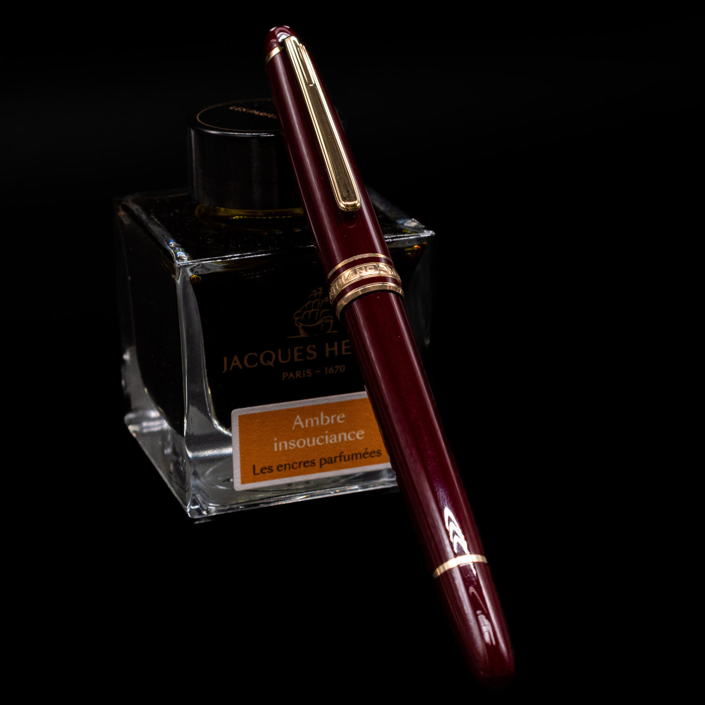 Montblanc Meisterstuck 144R Bordeaux Fountain Pen - Preowned capped, leaning against an ink bottle. 