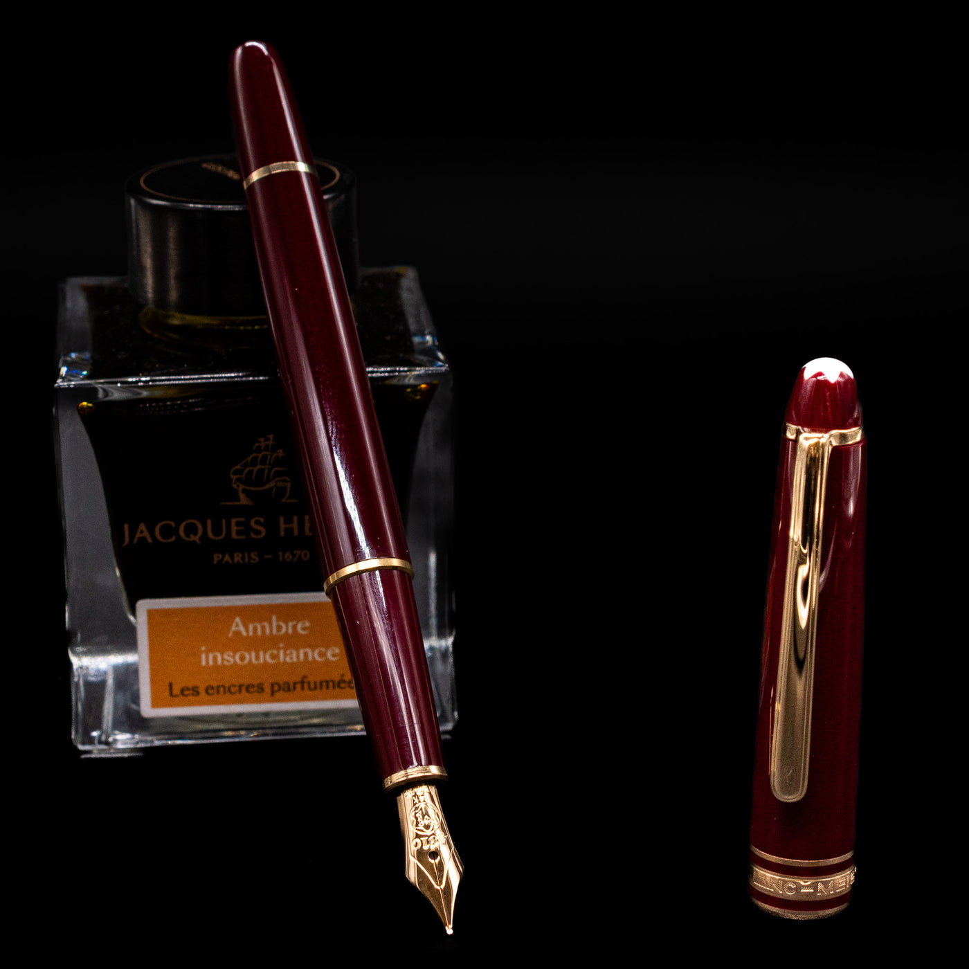 Montblanc Meisterstuck 144R Bordeaux Fountain Pen - Preowned leaning on an ink bottle uncapped showcasing the detailing on the nib.