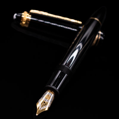 Montblanc Meisterstuck 146 75th Anniversary Special Edition LeGrand Fountain Pen - Preowned laying across its own cap, crossed, with a focus on the nib.