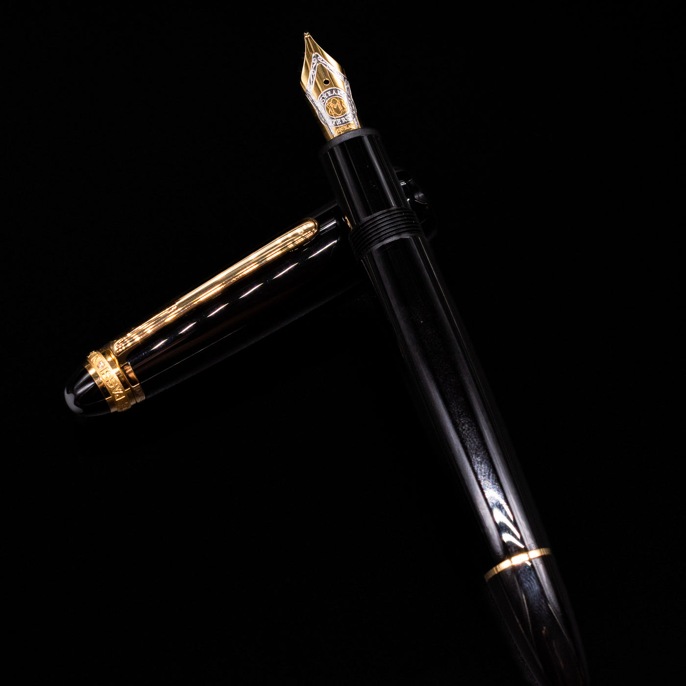 Montblanc Meisterstuck 146 75th Anniversary Special Edition LeGrand Fountain Pen - Preowned laying on top of its cap in a crossed position showing full view of the entire uncapped pen.
