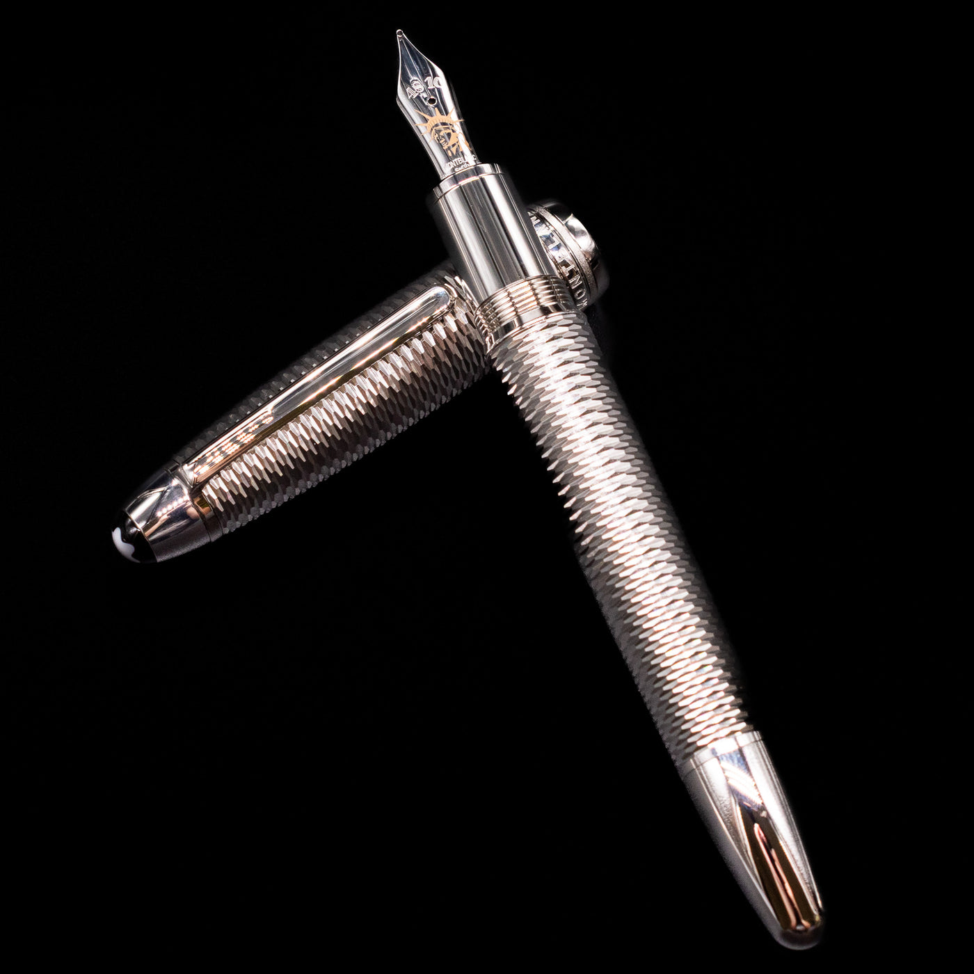 Montblanc Meisterstuck 146 Solitaire Geometry City Edition LeGrand Fountain Pen - New York laying on top of its cap in a crossed position showing full view of the entire uncapped pen.
